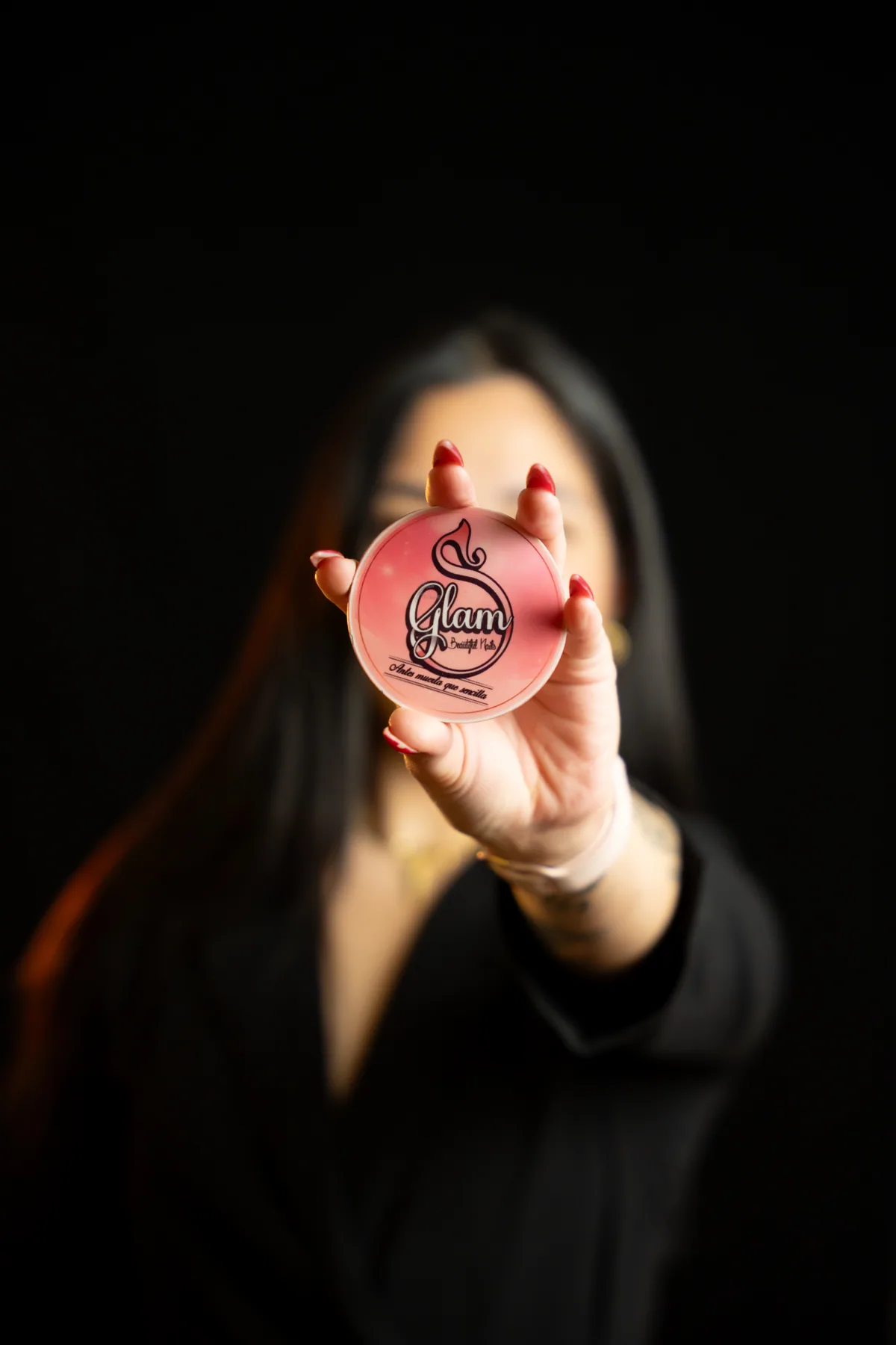 Sury Dayana Yela, instructora de Sury Glam, sosteniendo el disco de la marca Glam Beautiful Nails